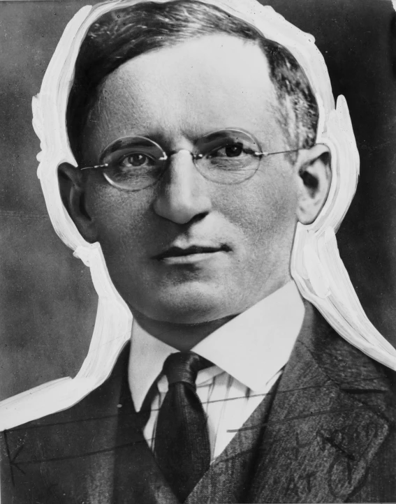 black and white image of a man with glasses wearing a suit and tie
