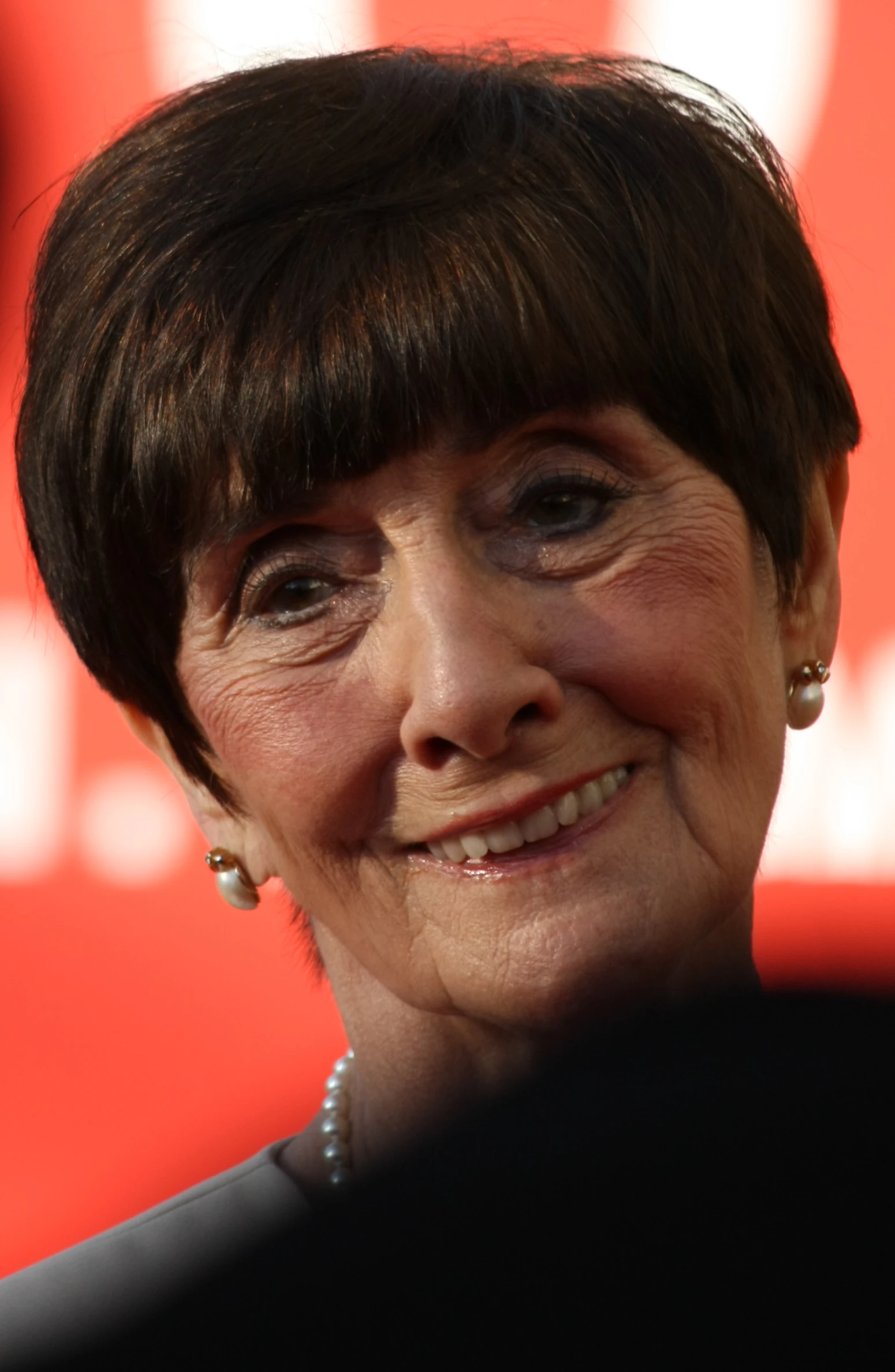 a smiling older woman at a public event