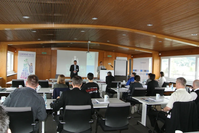 a large group of people sitting in front of laptops in a room