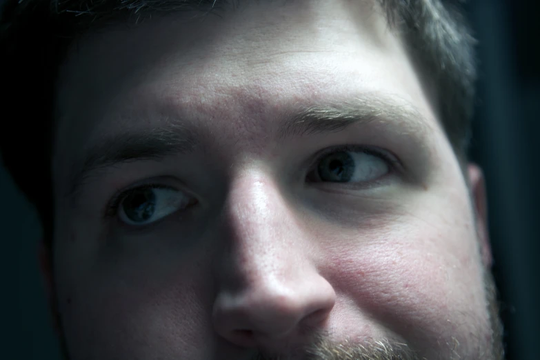 a young man looks to his left as he poses for the camera