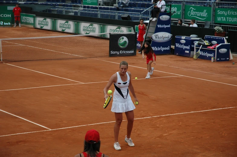 two women on a tennis court one holding a racquet