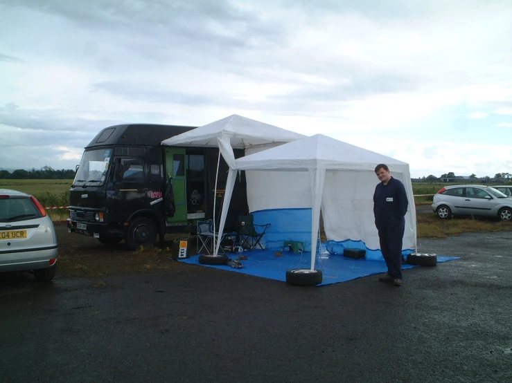 a person standing near a large white tent