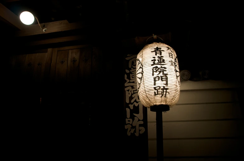 a lamp in the dark next to a building