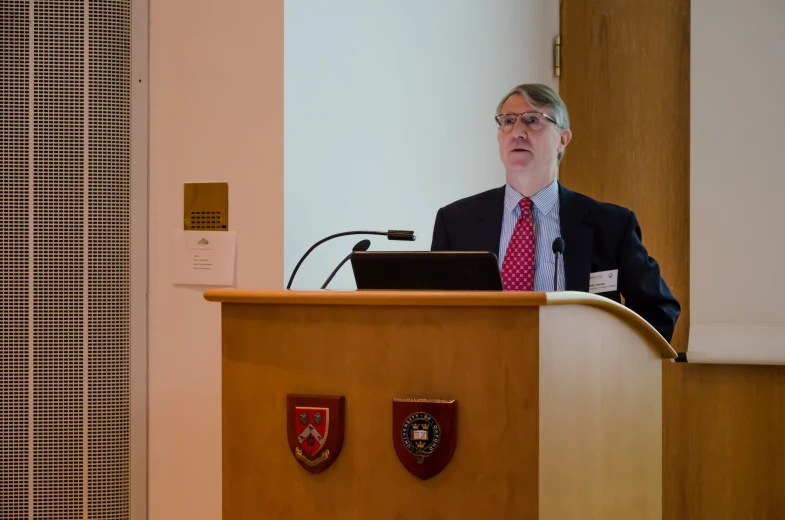 a man is speaking at a podium while he's standing