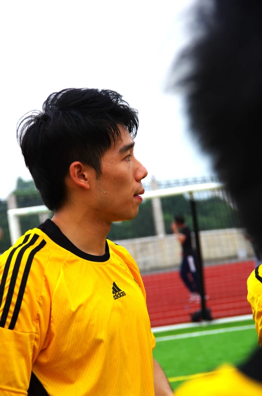 a soccer player in uniform talks to his coach