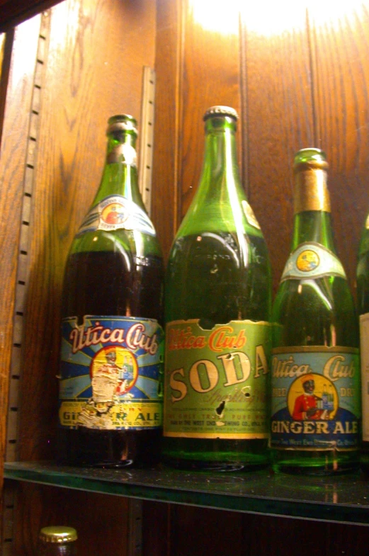 a row of bottles on top of a wooden shelf