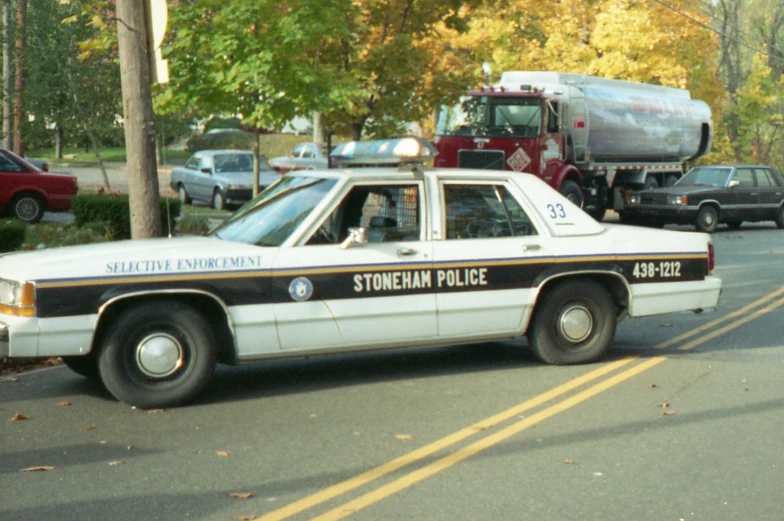 the white, black and brown police car is parked