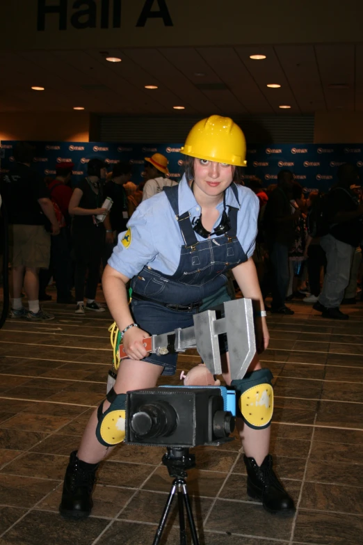 a woman in an overalls is holding a small tool