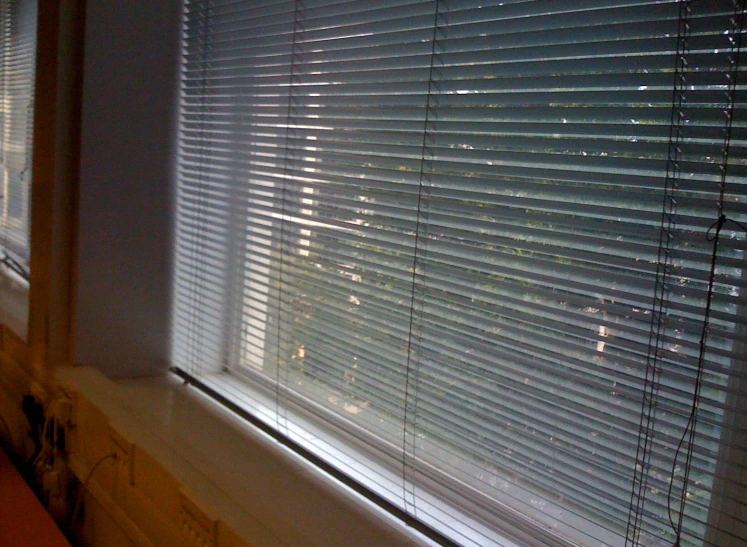 close up of white blinds in an otherwise empty room