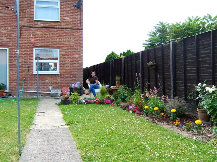 two people are sitting outside in a back yard