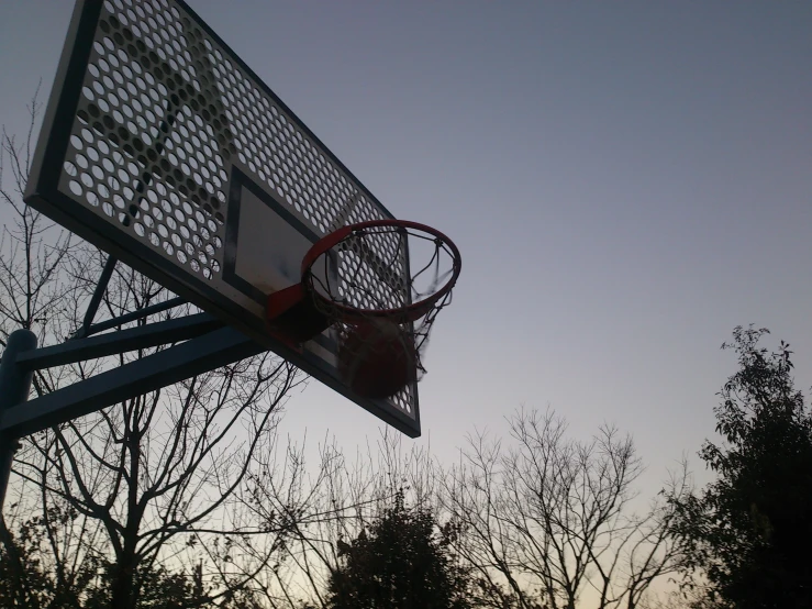 a basketball hoop with a backboard next to some trees