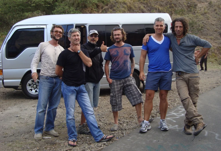 six men in front of a white van giving the thumbs up