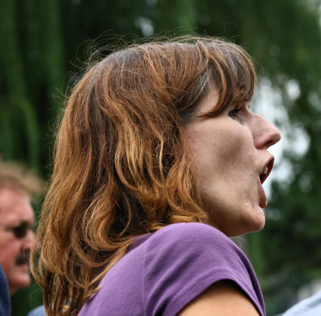 a woman with her mouth open making an obscene gesture