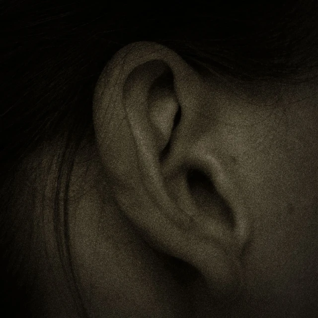a single earring on top of an individual ear