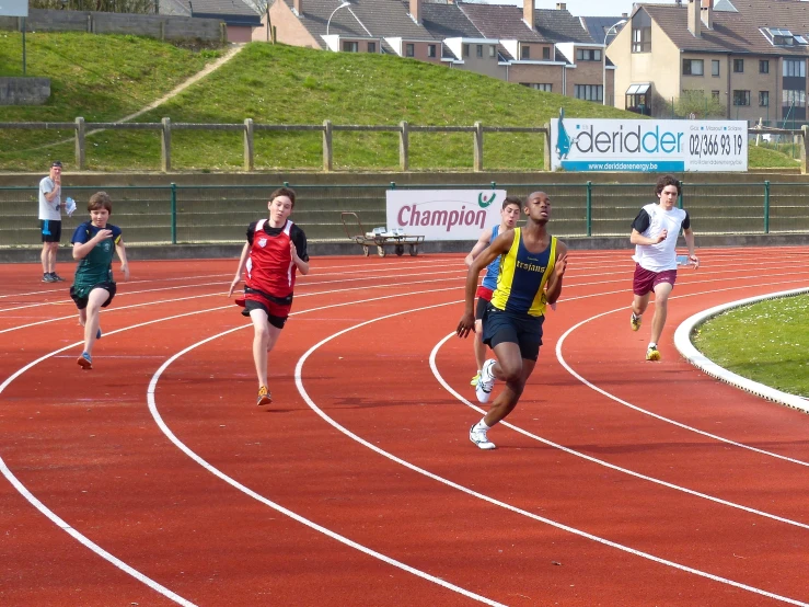 children running on a race track outside in the sun