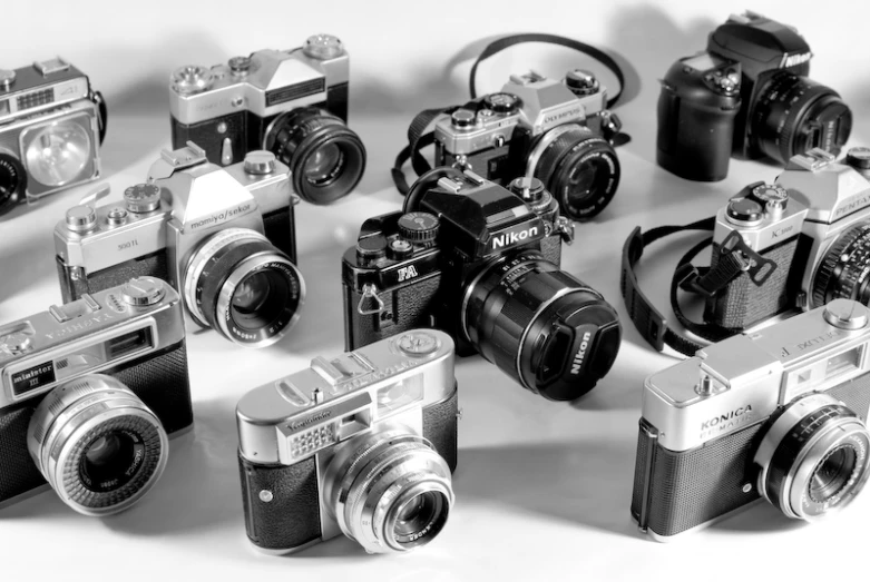 several vintage cameras on white with black straps