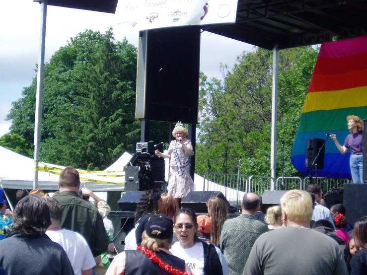 woman with grey hair on stage speaking to people