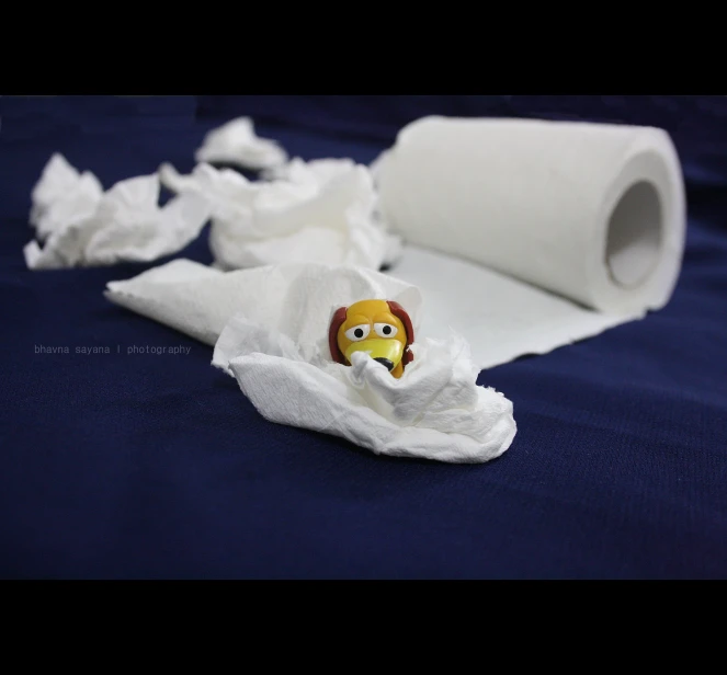 a roll of toilet paper and a doll face