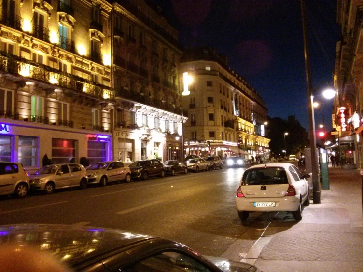 a car drives down a city street at night