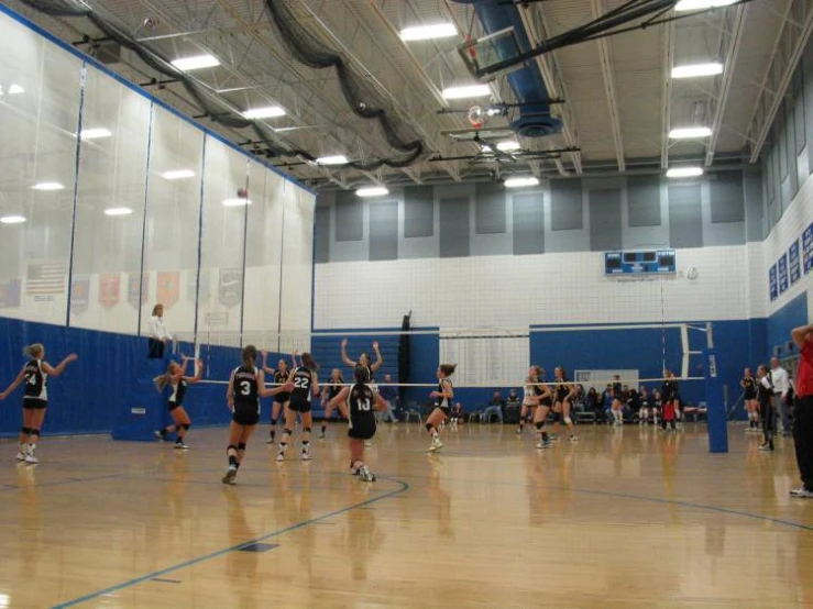 some people playing volleyball in a gym together