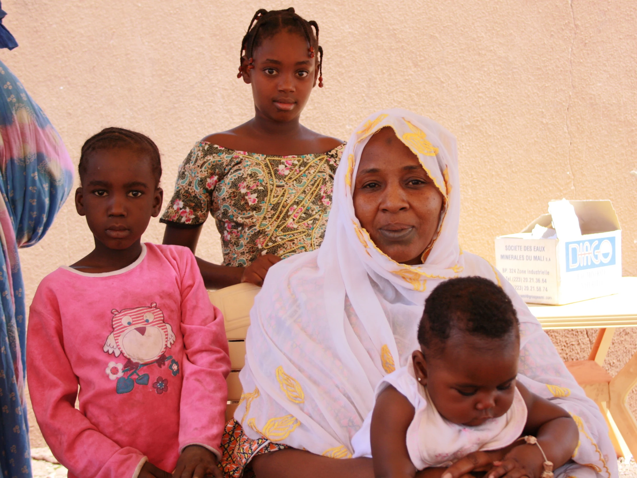 a group of women and children sitting on a bench