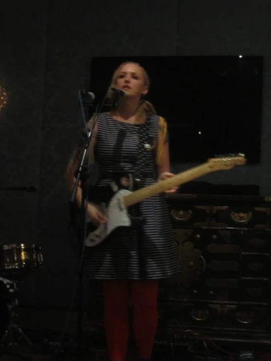 a woman with red boots holding a guitar