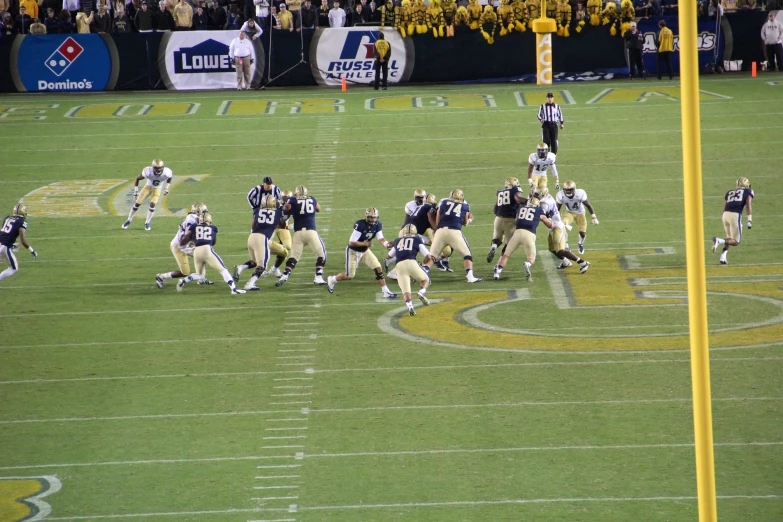 two teams playing football in front of the crowd