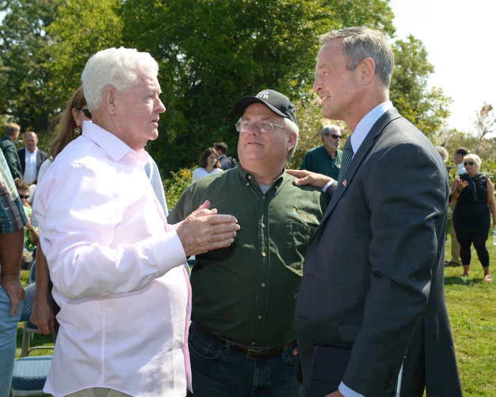 two men are standing in a circle with other people