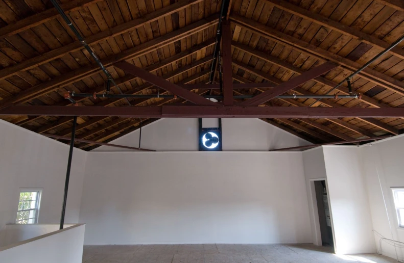 an open building with wooden beams and a sign