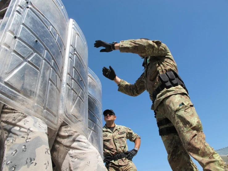 two military officers putting items into plastic containers