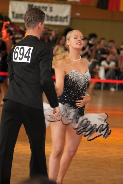 a woman in a gown with short legs on the dance floor