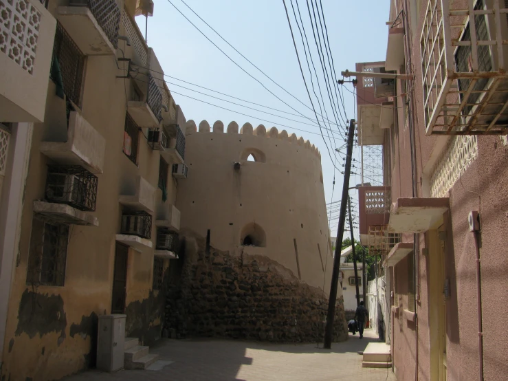 an alley leading to a massive and very tall building