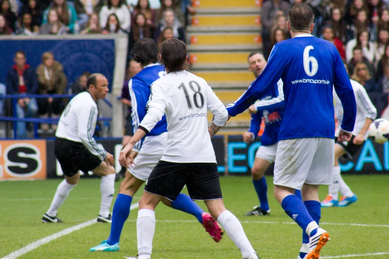 the two opposing teams are playing soccer while people look on