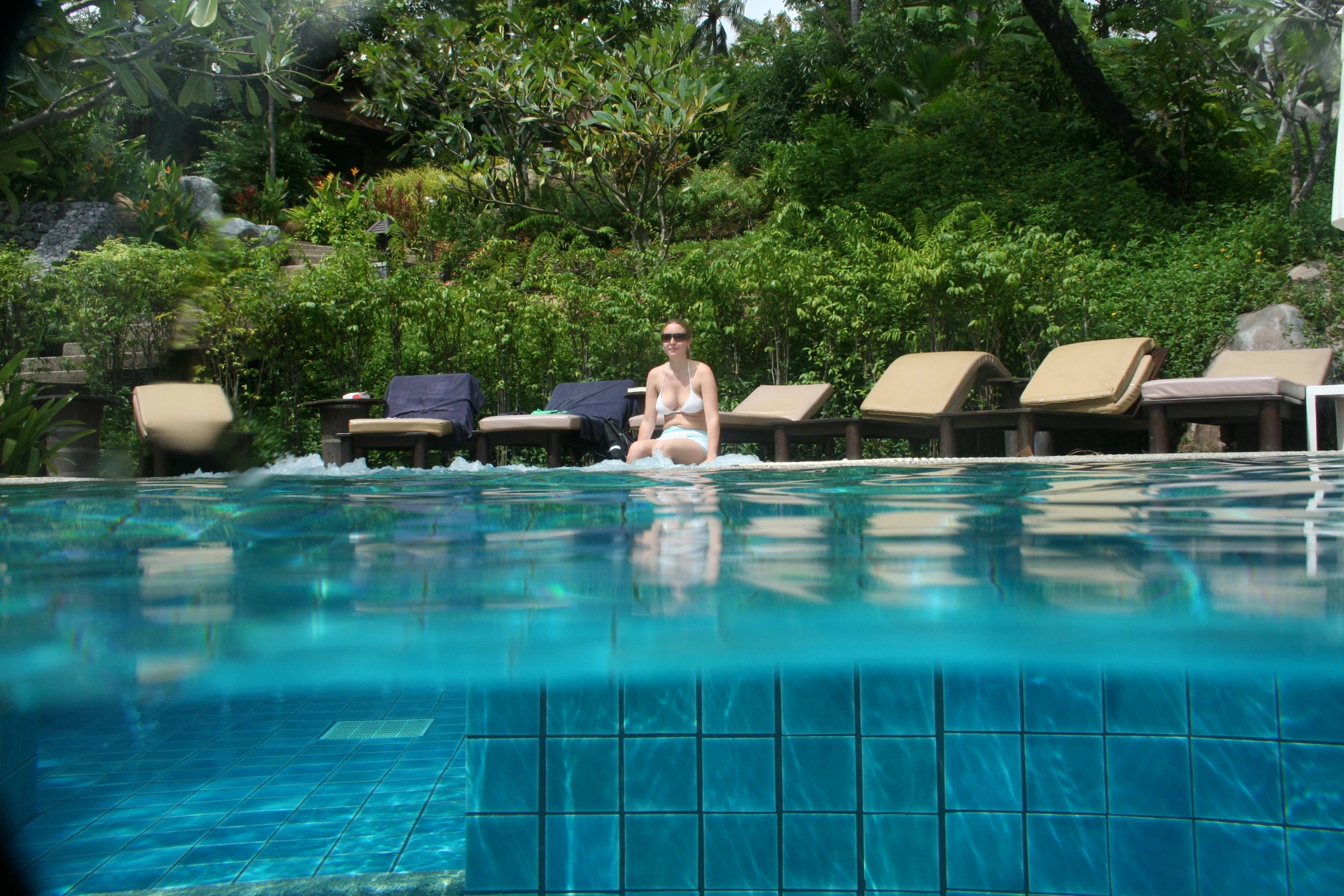 a woman in the water next to an umbrella