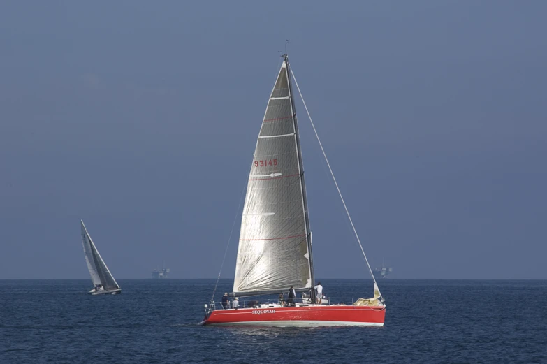 two sailboats sailing on the open sea in the day