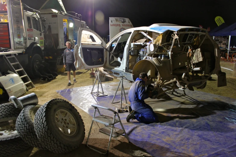 a man works on the rear of a vehicle