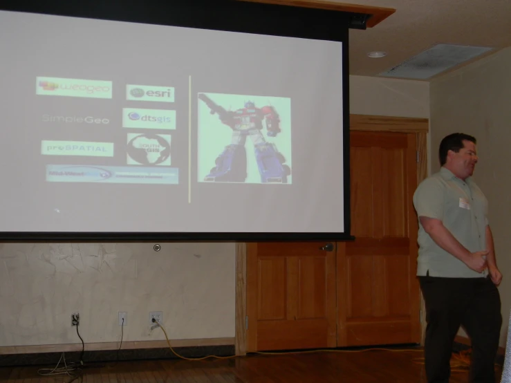 there is a man standing in front of a large projector screen