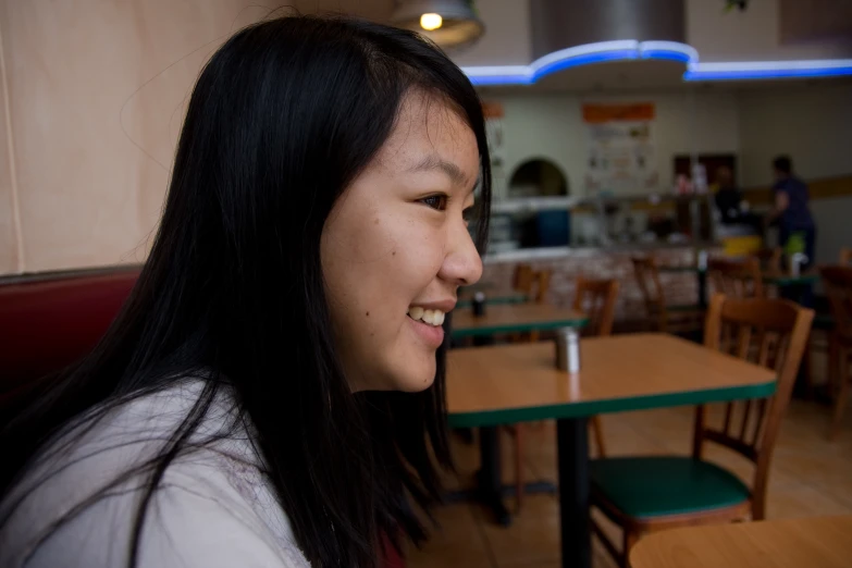 a woman who is smiling at a restaurant table