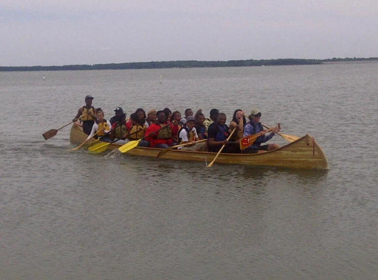 a long wooden boat with many people in it