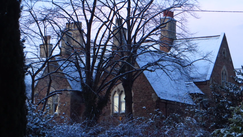 a snow - covered tree line and an old church in the background