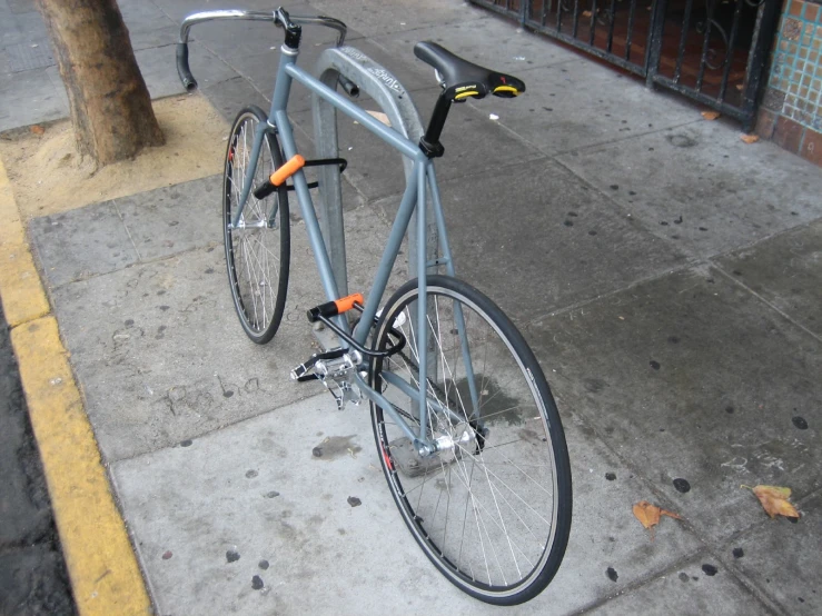 a bicycle parked on a city street next to a sidewalk