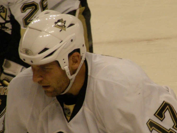 a hockey player walking on the ice while wearing a helmet