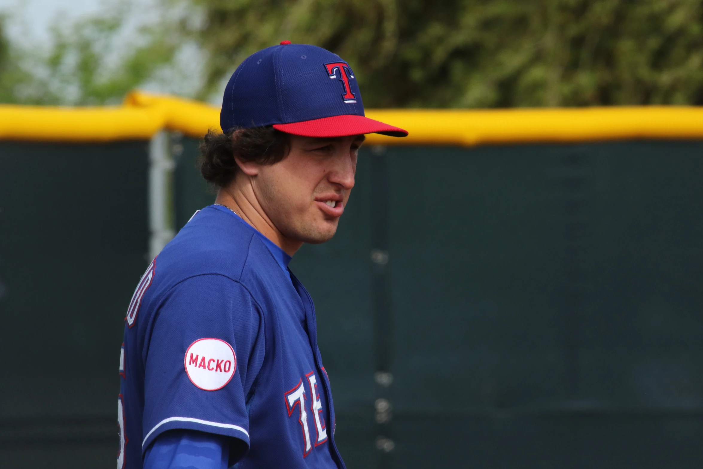 baseball player wearing a mets uniform standing next to an empty baseball diamond