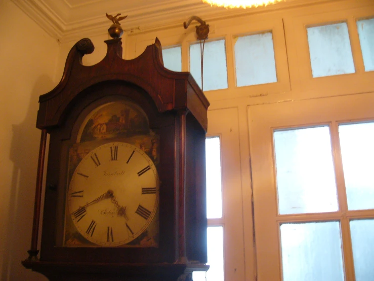 a large ornate wooden clock is in a white room