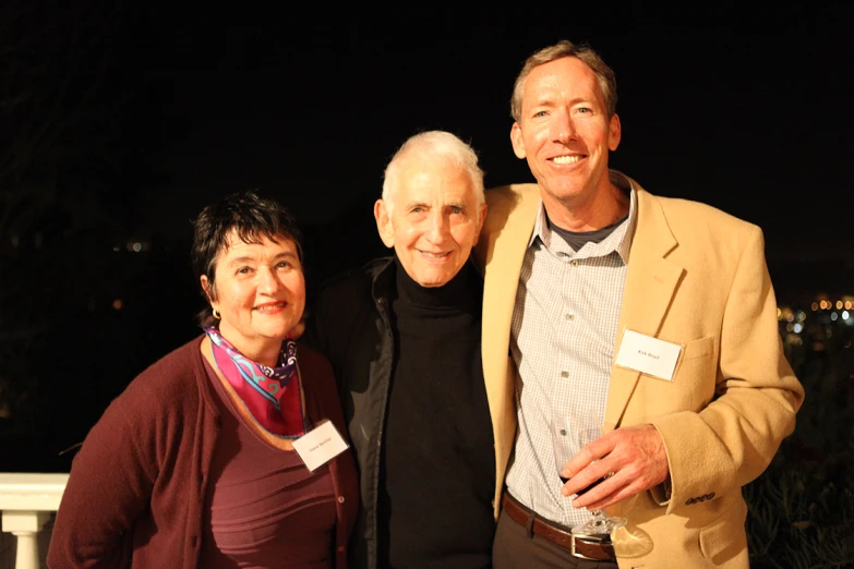 three people smile while posing for a po