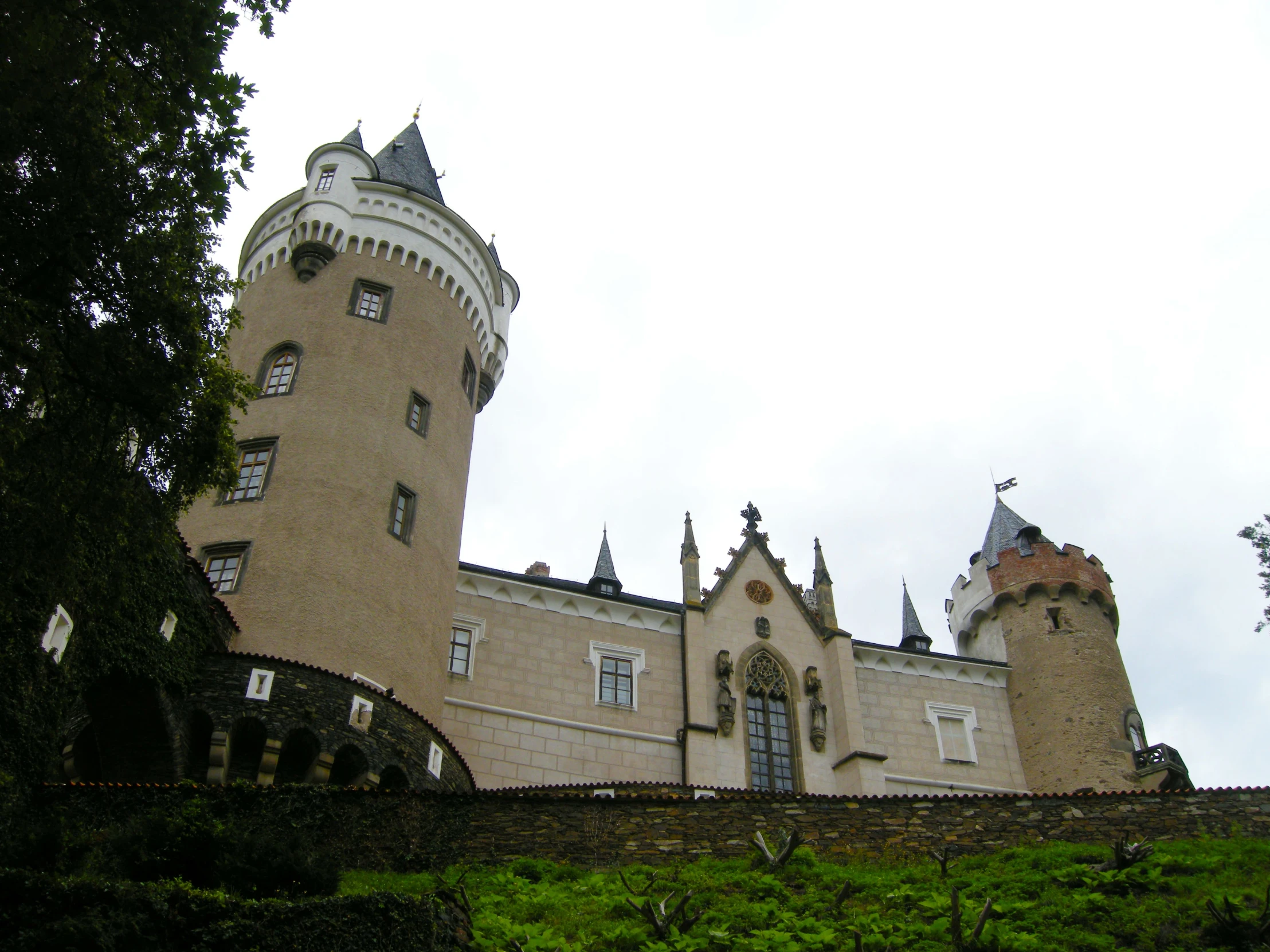 a building with a tower made of brick and lots of grass