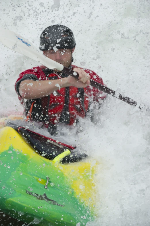 a man is seen paddling a green boat in the water