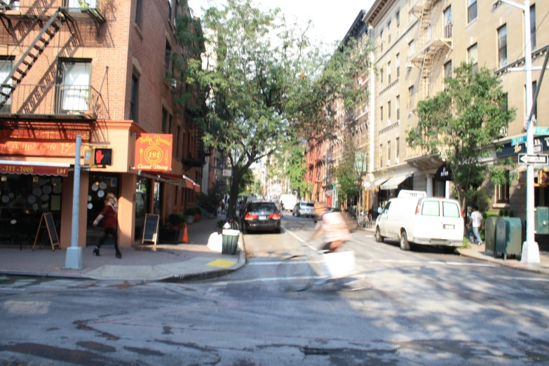 a person riding an orange scooter down the street