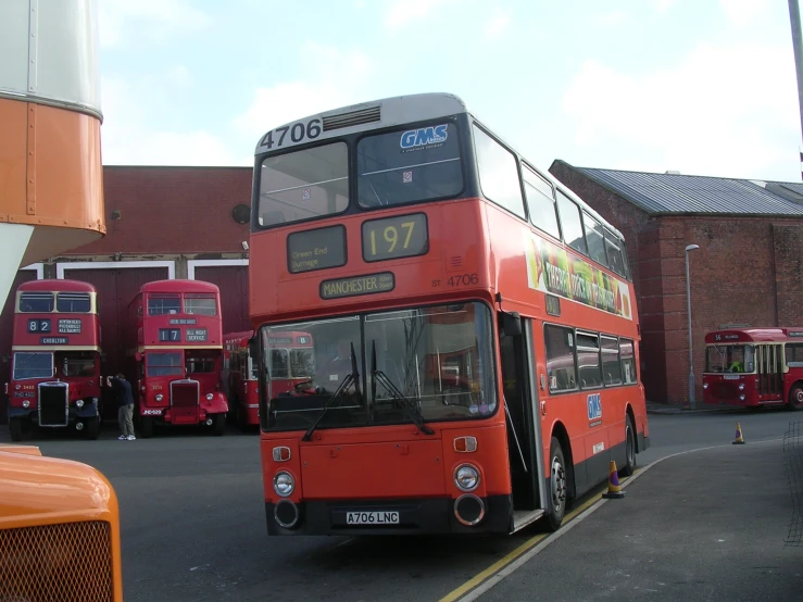 a red double decker bus is driving down the street