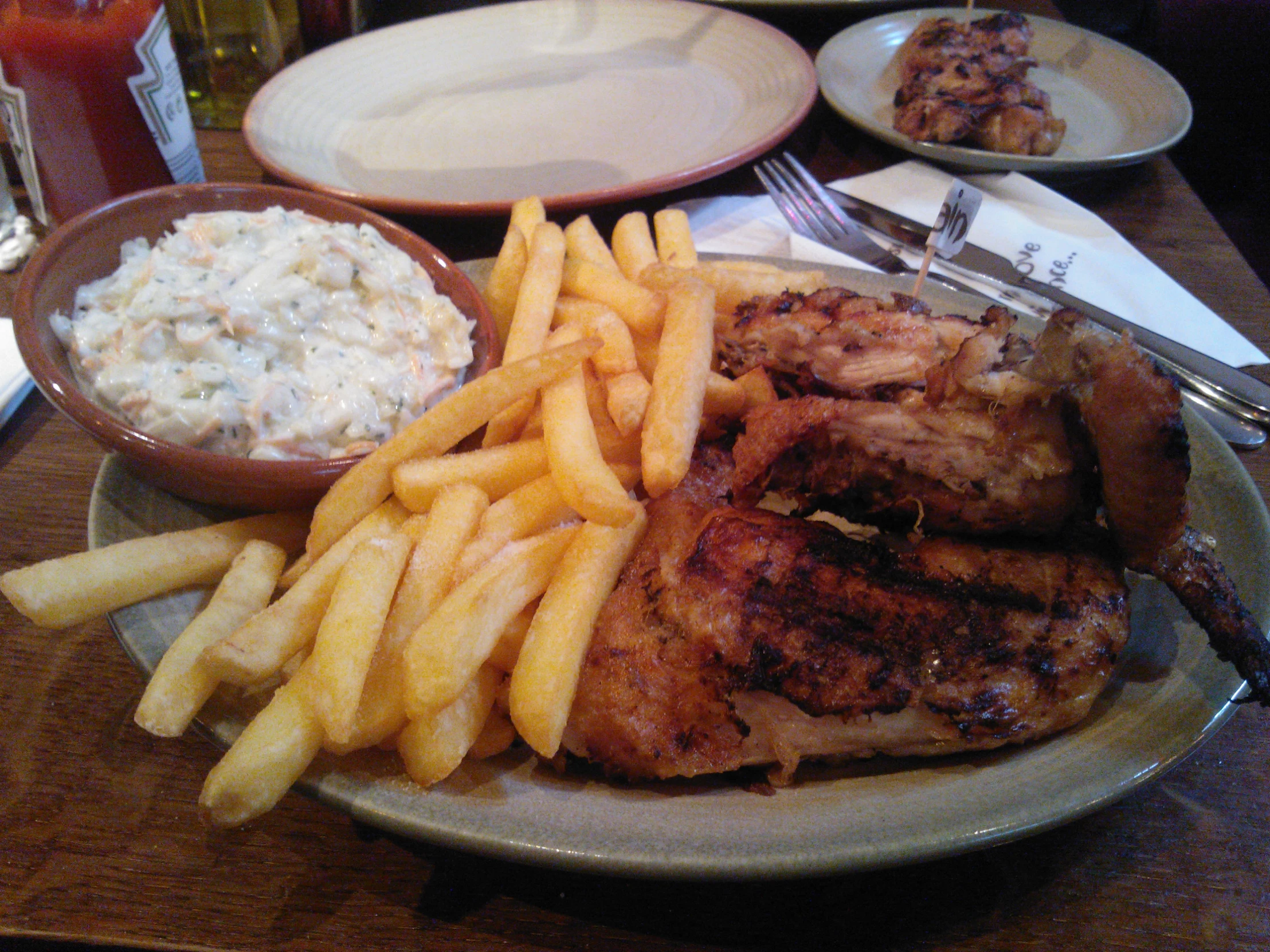 french fries on the side of a plate that is next to a chicken